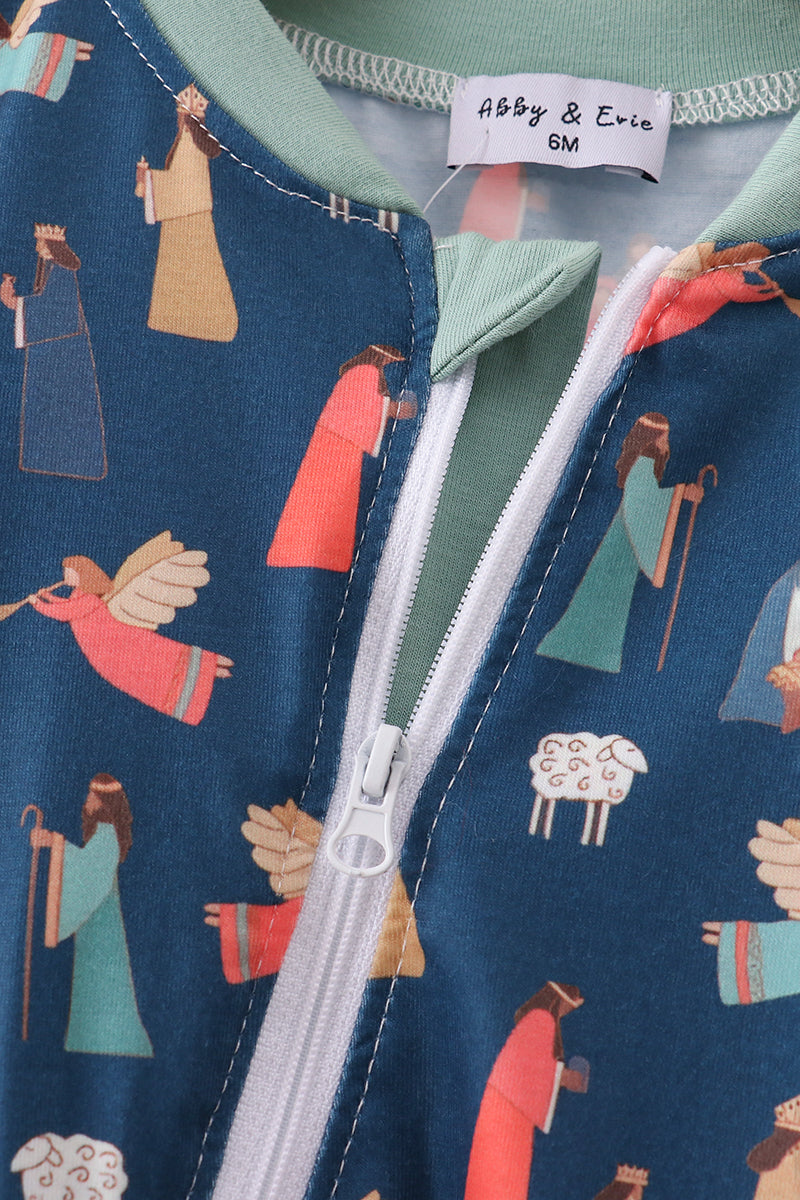 Close-up of a baby romper with nativity scene print and 'Abby & Evie' label.