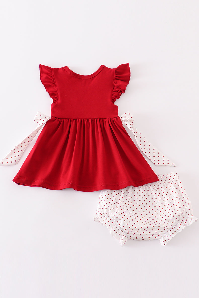 Red dress with ruffled sleeves and white shorts with polka dots on a white background
