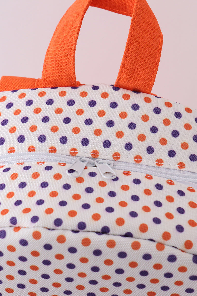 Close-up of a fabric with orange and blue polka dot pattern.