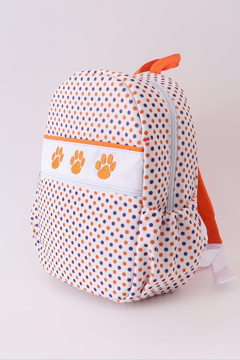 Backpack with polka dot pattern and orange accents on a plain background