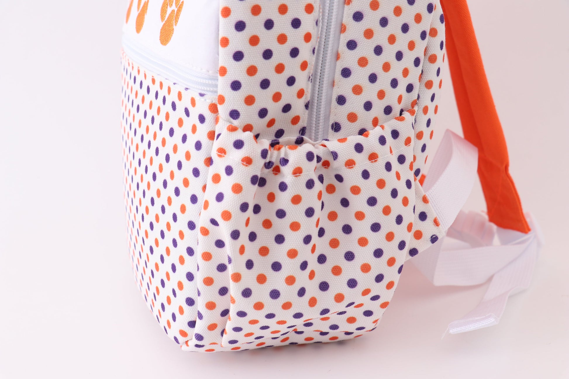Backpack with polka dot pattern on a plain background