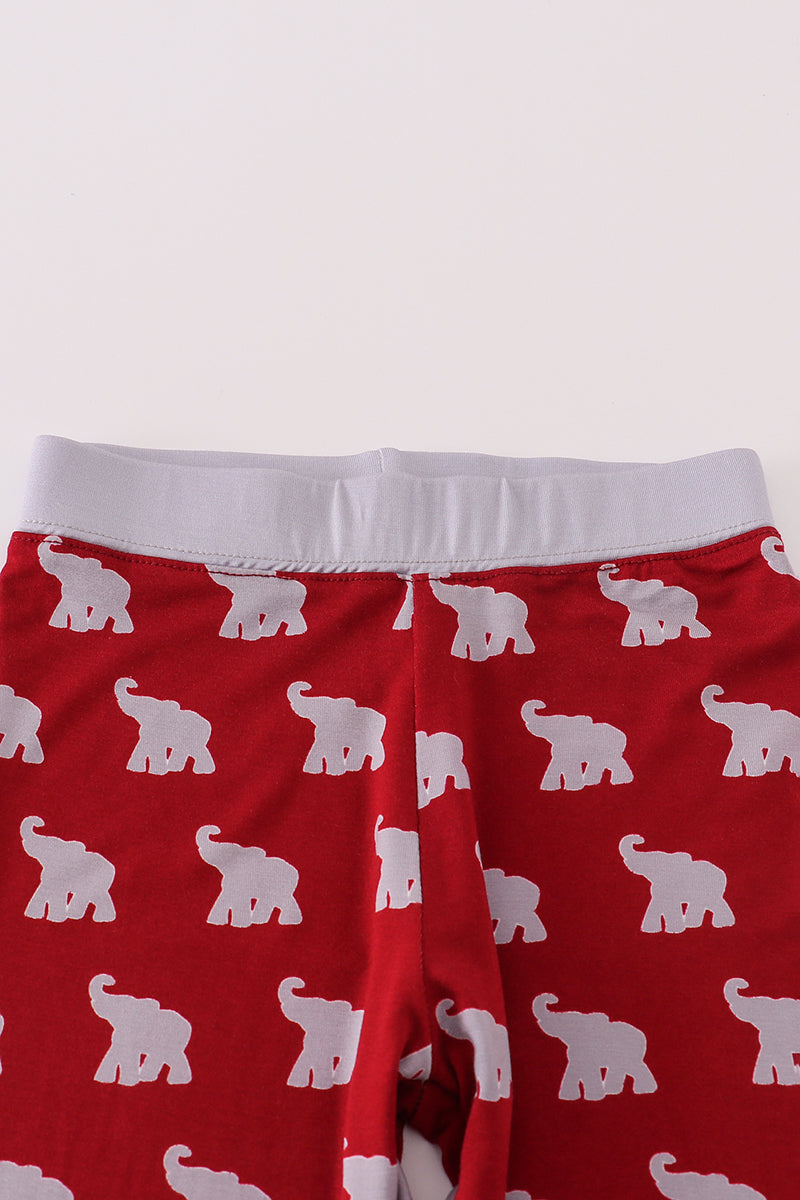 Red pants with white elephant pattern on a light gray background