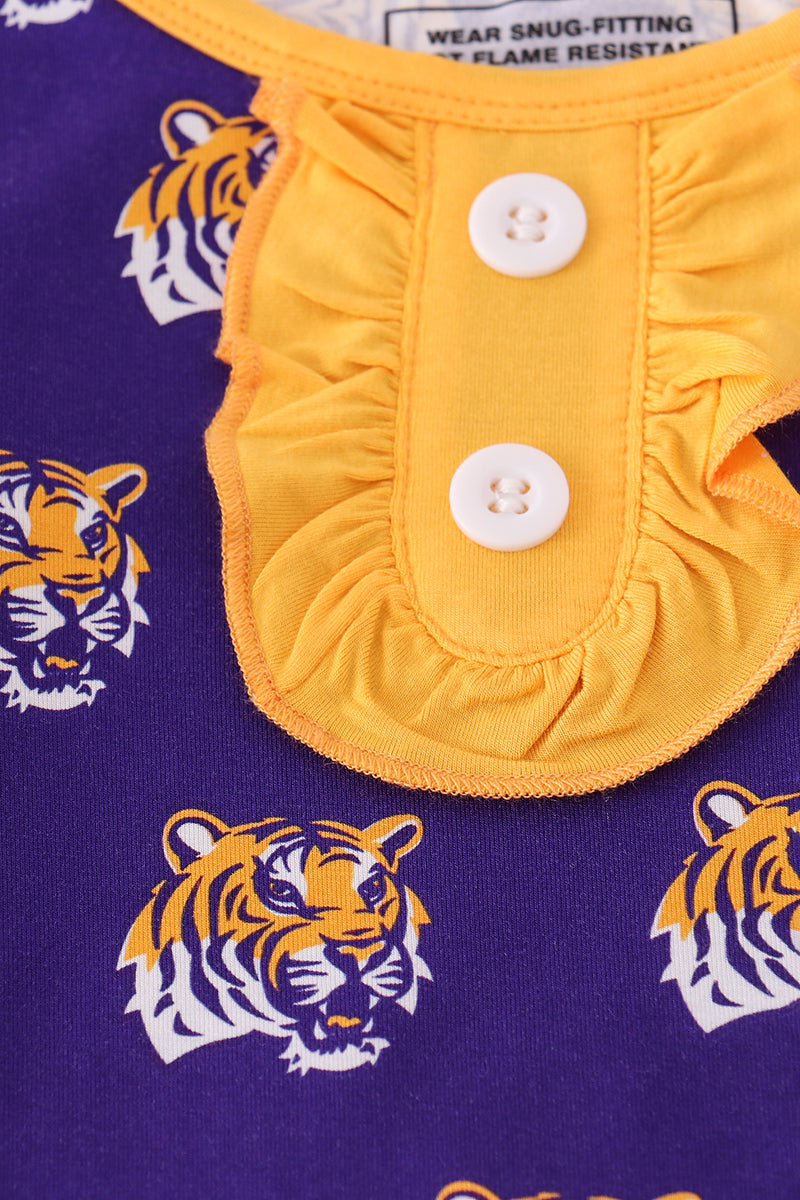 Close-up of yellow fabric with buttons on a purple background featuring tiger logos.
