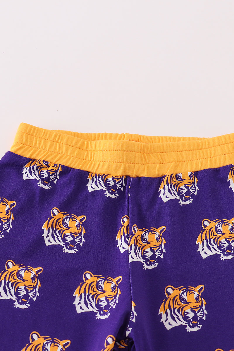Purple shorts with tiger pattern and yellow waistband on a light gray background