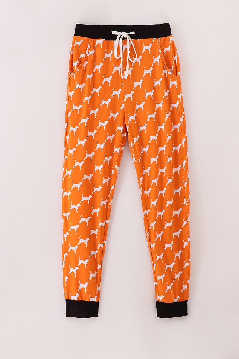 Orange pajama pants with white dog pattern on a light gray background