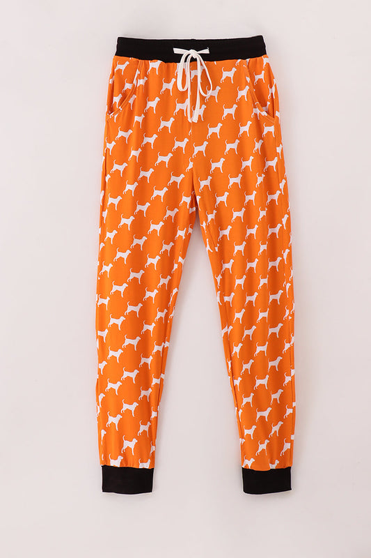Orange pajama pants with white dog pattern on a light gray background