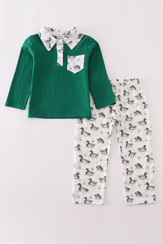 Children's outfit with green long-sleeve shirt and patterned pants on a light gray background