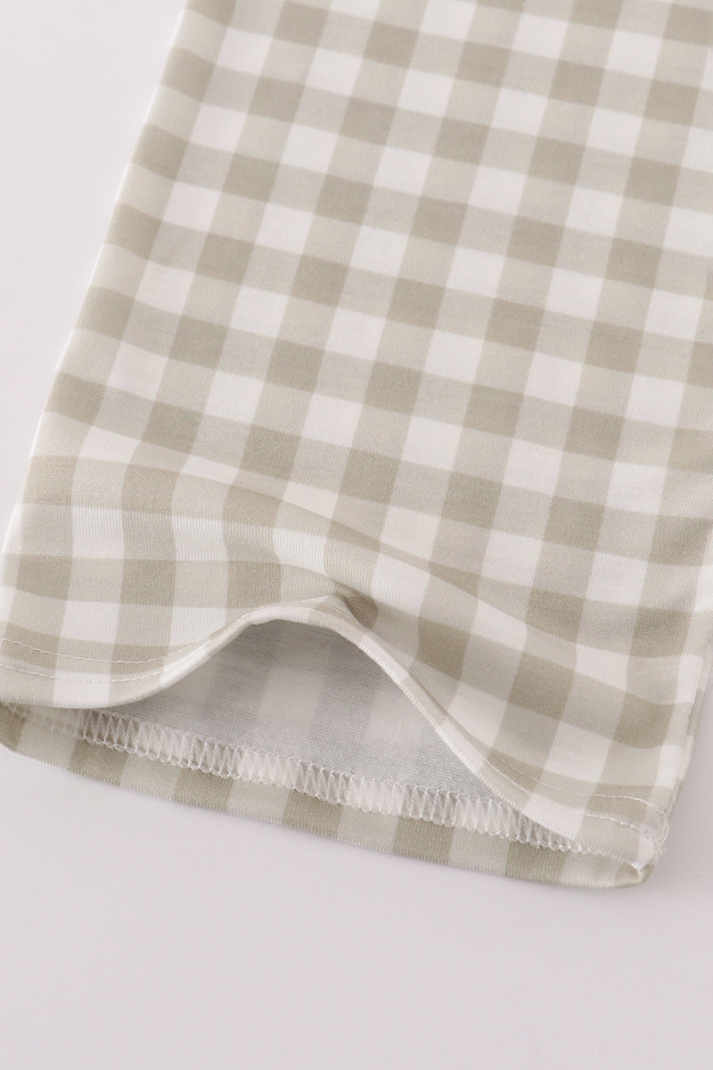 Folded checkered fabric with a green and white pattern on a light gray background