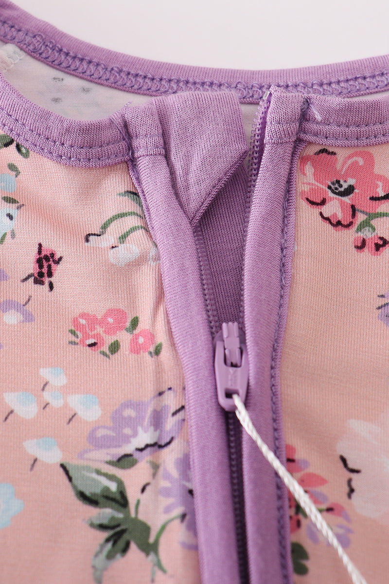 Close-up of a floral-patterned garment with a purple zipper.