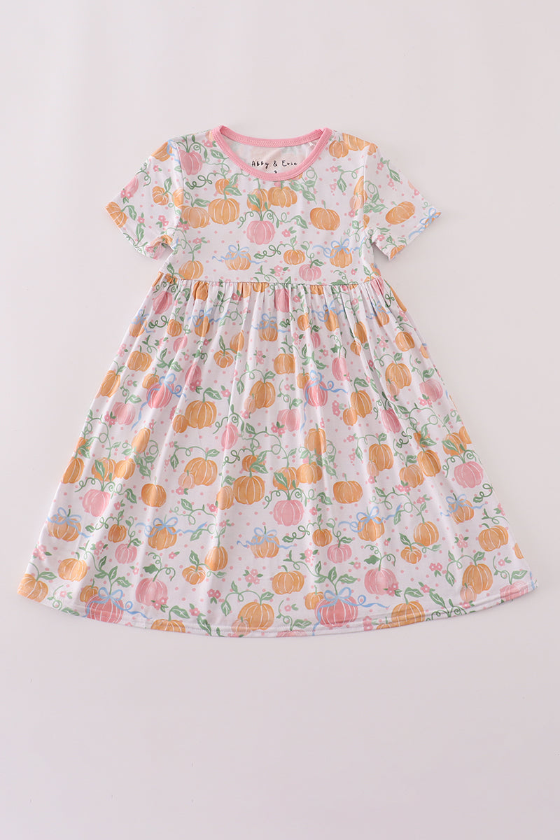 Children's dress with pumpkin and floral pattern on a light gray background