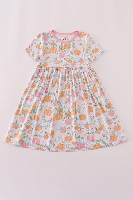 Children's dress with pumpkin and floral pattern on a light gray background