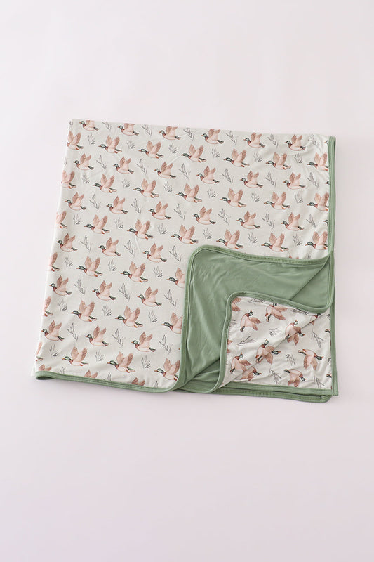 Folded blanket with bird pattern on a light gray background