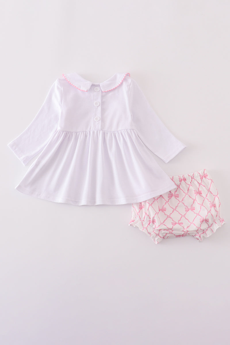 White dress with pink floral bloomers on a light gray background