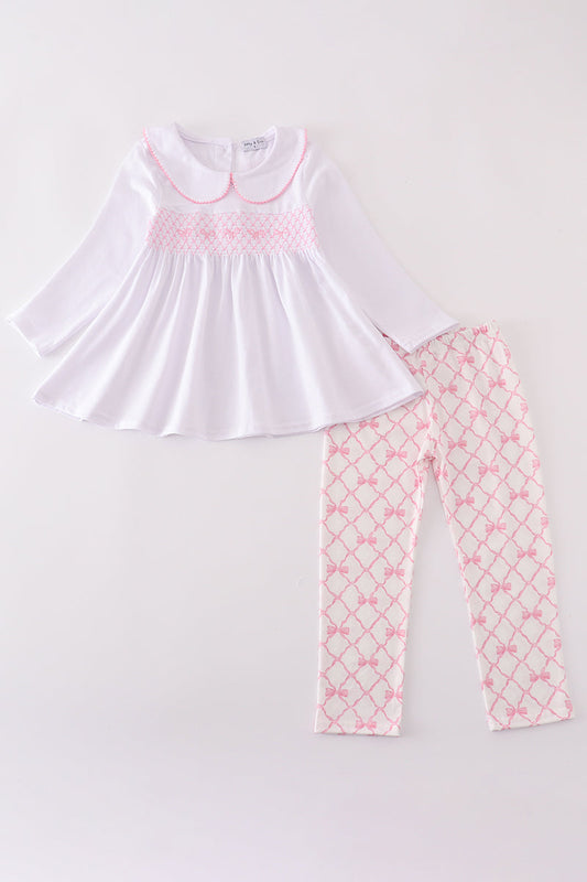 White top with pink smocking and matching pants on a white background