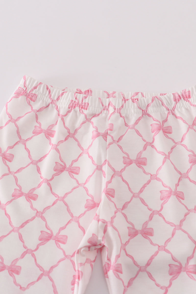 Pink and white patterned pants with a grid design on a light gray background