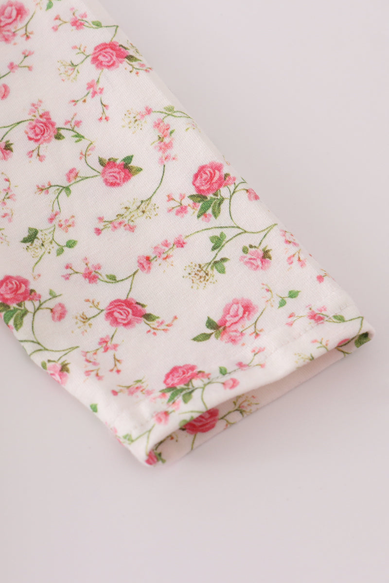 Floral fabric with pink roses and green leaves on a white background