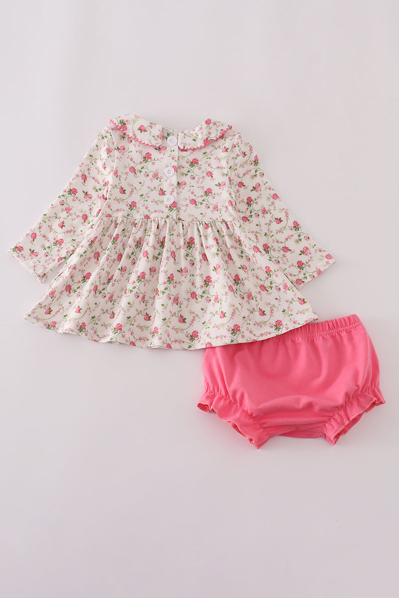 Floral dress and pink bloomers on a light gray background