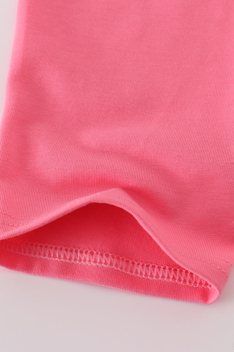 Close-up of pink fabric with a visible seam on a light gray background