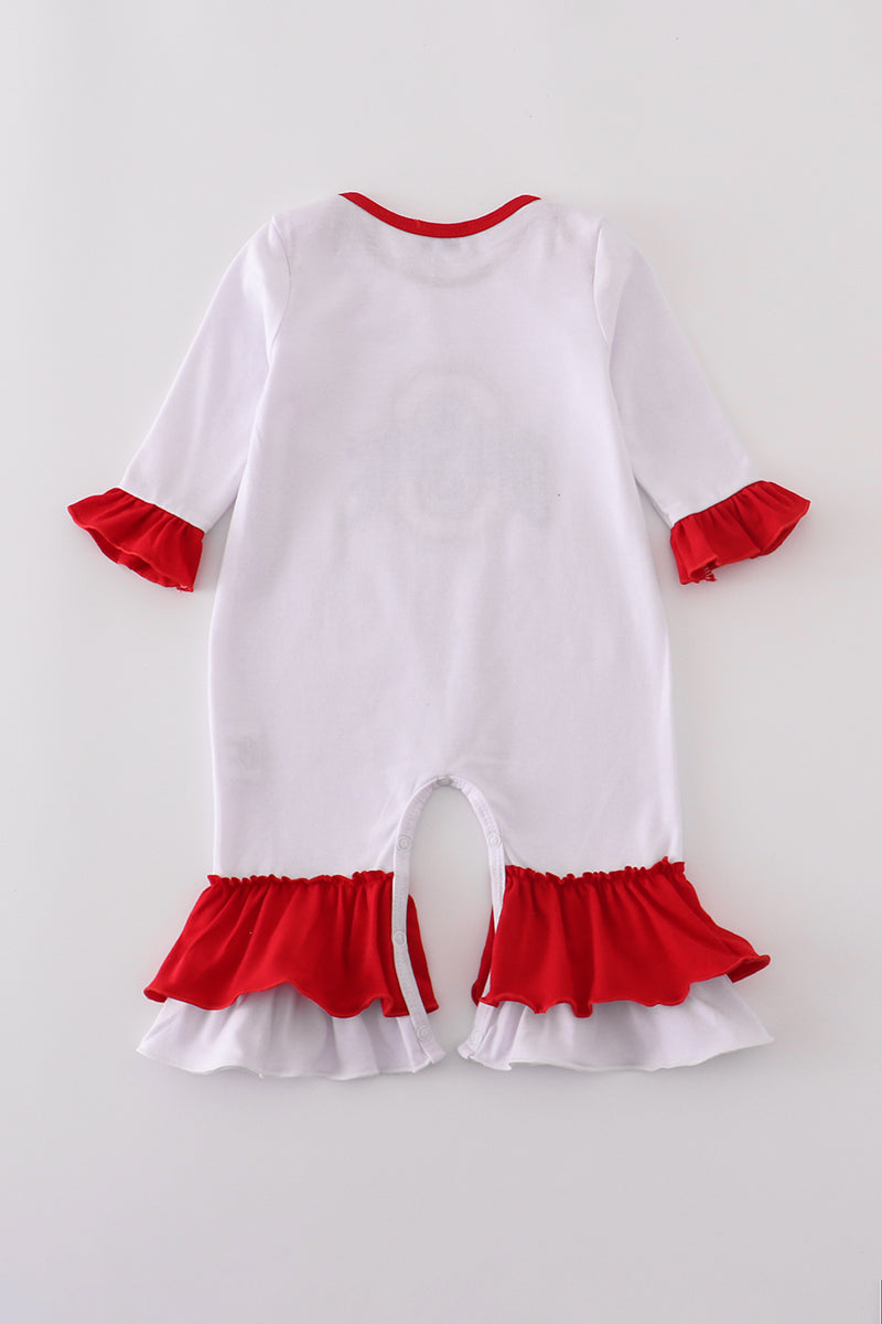 White baby romper with red ruffles on a light gray background