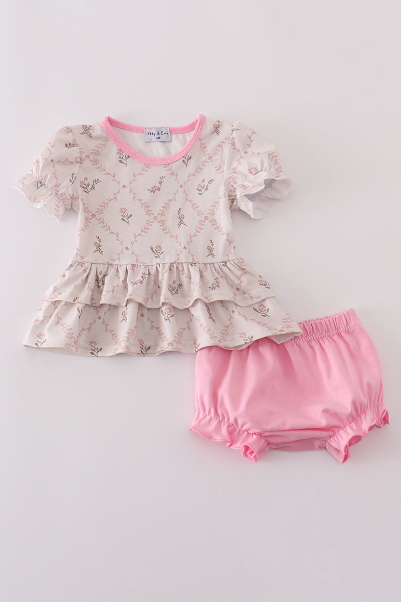 Baby outfit with floral top and pink bloomers on a light gray background