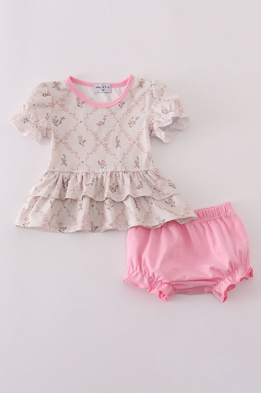 Baby outfit with floral top and pink bloomers on a light gray background