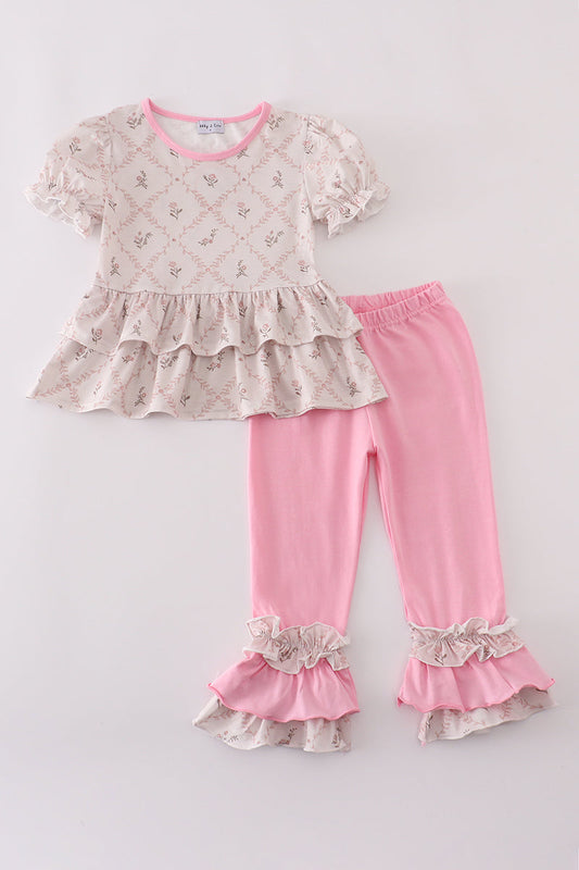 Children's outfit with a floral top and pink pants on a white background