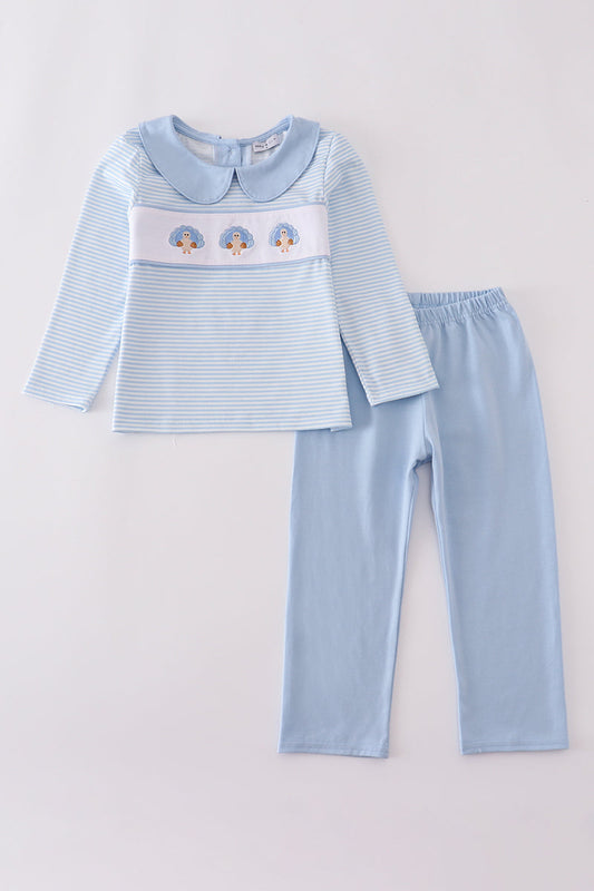 Light blue children's outfit with embroidered design on a white background
