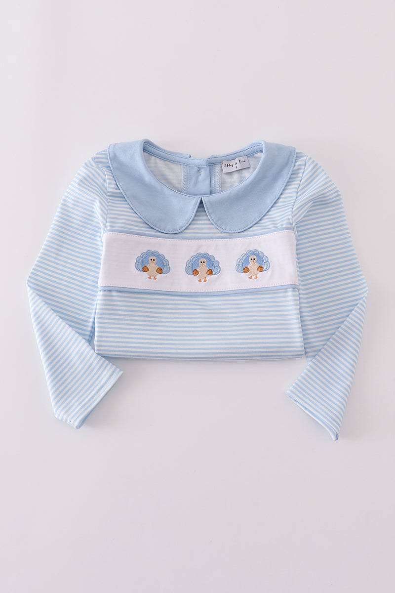 Light blue striped shirt with a Peter Pan collar and embroidered design on a light gray background