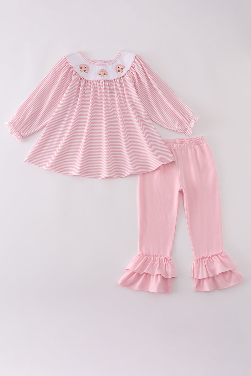 Pink striped top and ruffled pants set on a light gray background
