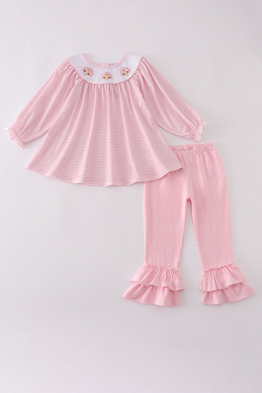 Pink striped top and ruffled pants set on a light gray background