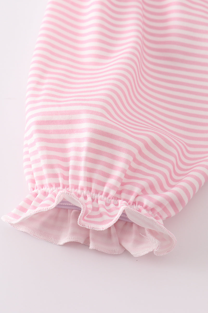 Close-up of a pink and white striped fabric with ruffled edge on a light gray background