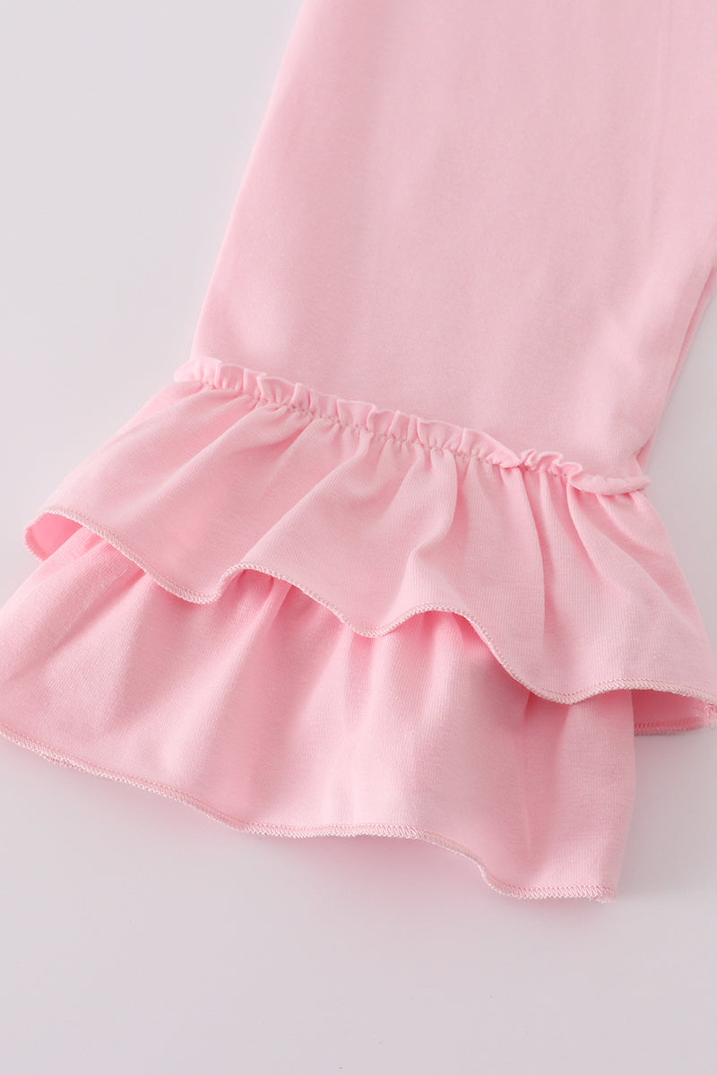 Close-up of a pink dress with ruffled hem on a light gray background
