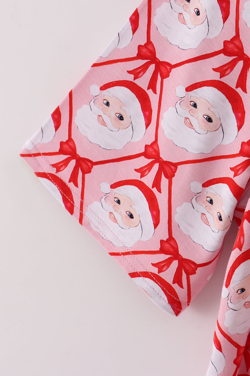 Pink fabric with Santa Claus and bow pattern on a light pink background