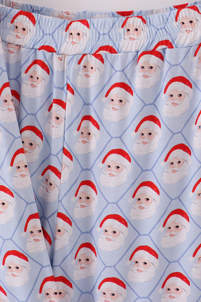 Patterned fabric with repeated image of a face wearing a red hat on a blue background