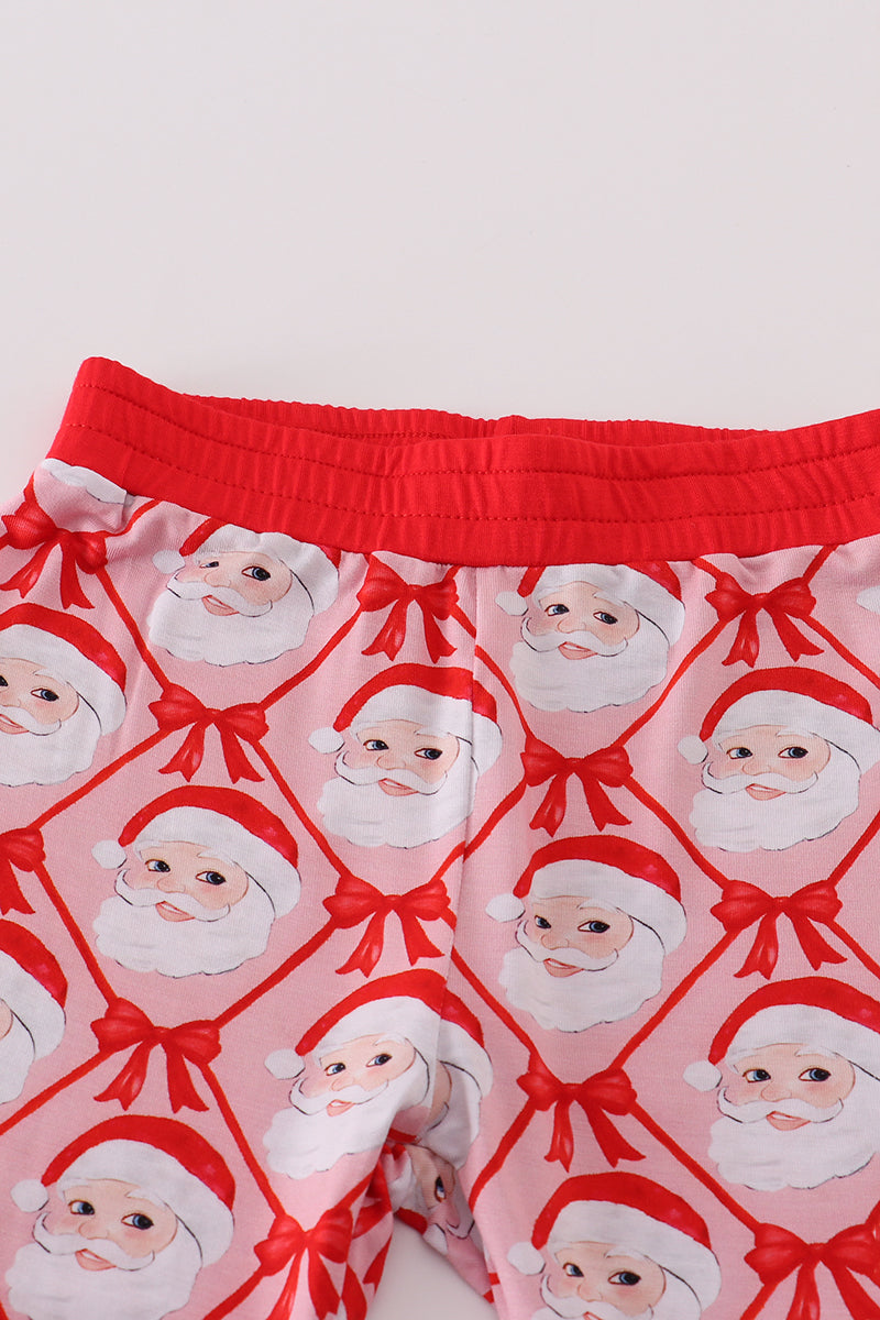 Pink pajama pants with Santa Claus pattern on a white background