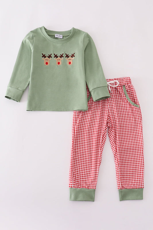 Children's pajama set with green top and red checkered pants on a light gray background