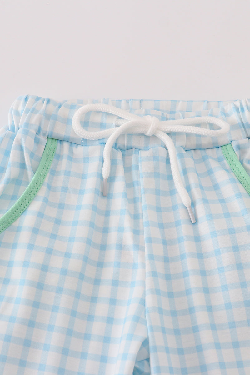 Light blue and white checkered shorts with a white drawstring on a light gray background