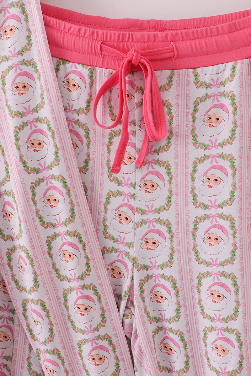 Pink pajama pants with a pattern of cartoon faces and bows on a white background.