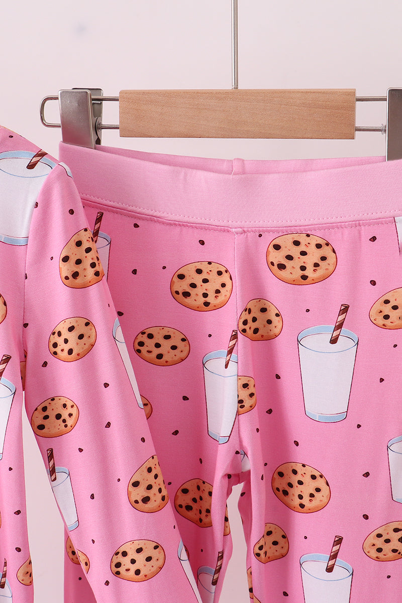 Pink apron with cookie and milk design hanging on a rack