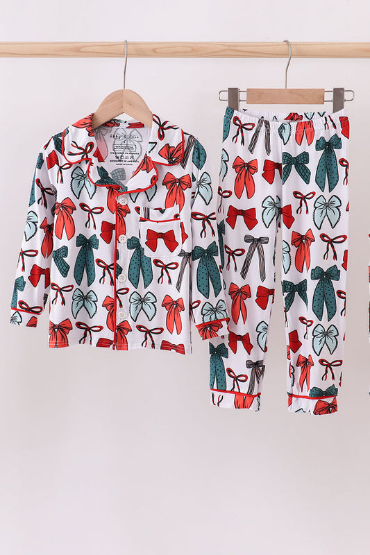 Pyjama set with bow pattern on hangers against a white background