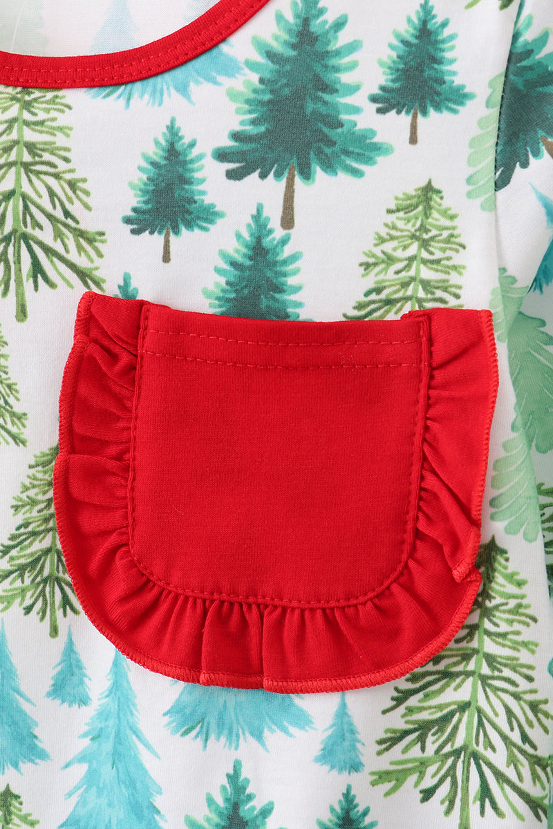 Close-up of a red pocket on a garment with a pattern of green trees on a white background.