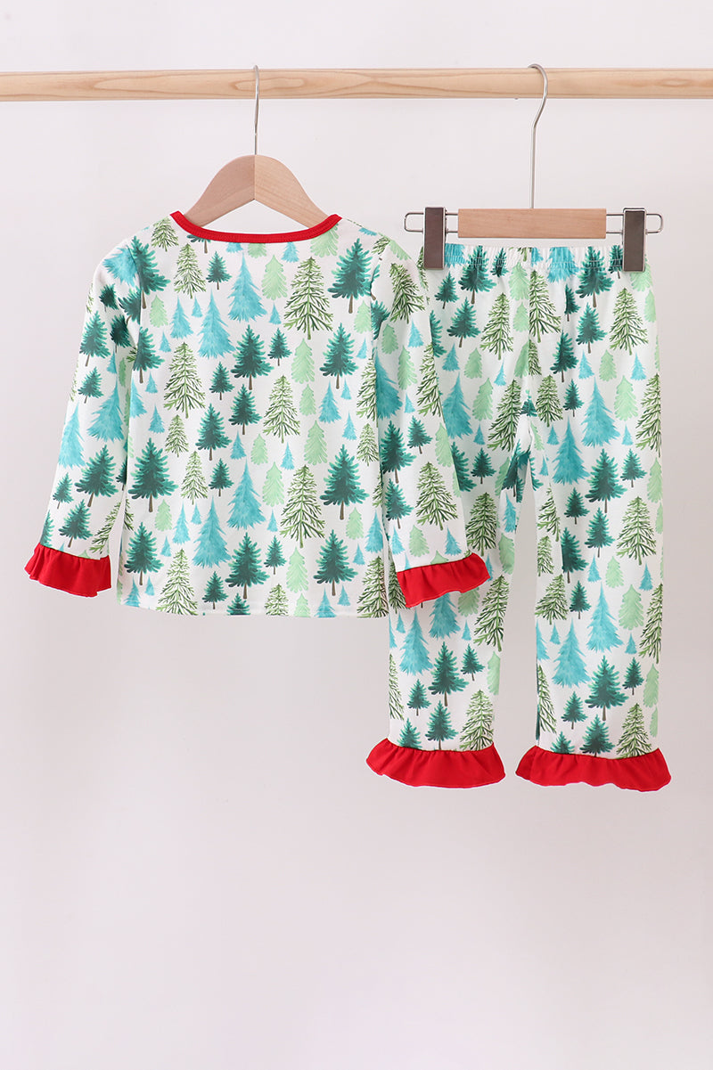 Children's pajama set with tree pattern and red trim on a hanger against a white background