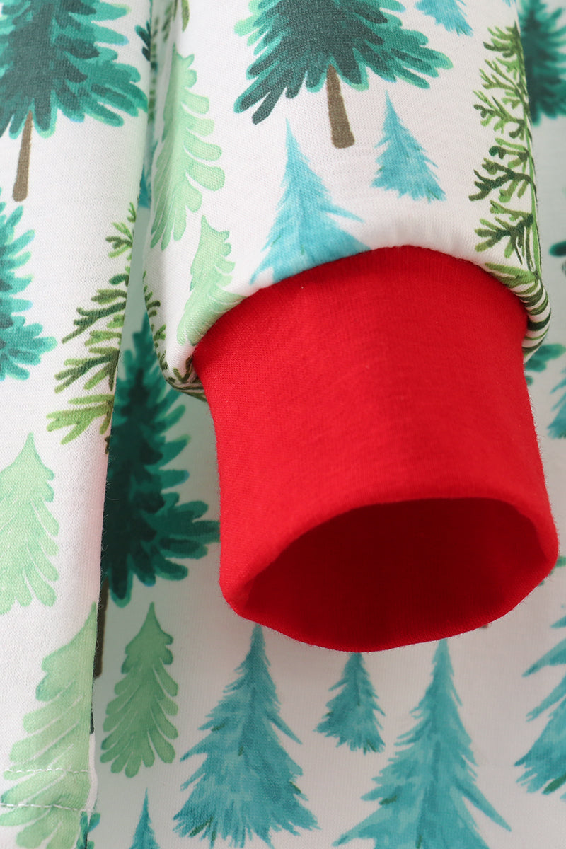 Red cup cozy on a fabric with green and blue tree pattern