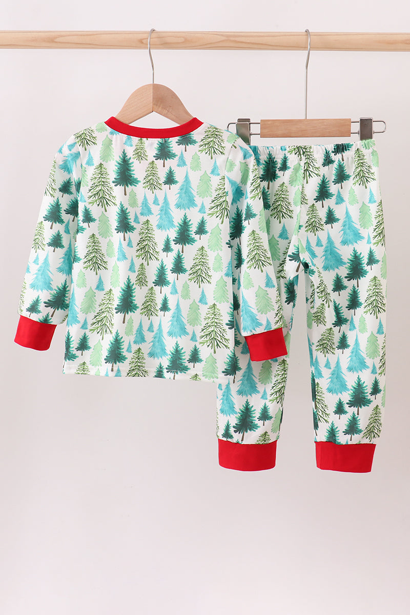 Children's pajama set with forest pattern on a hanger against a white background
