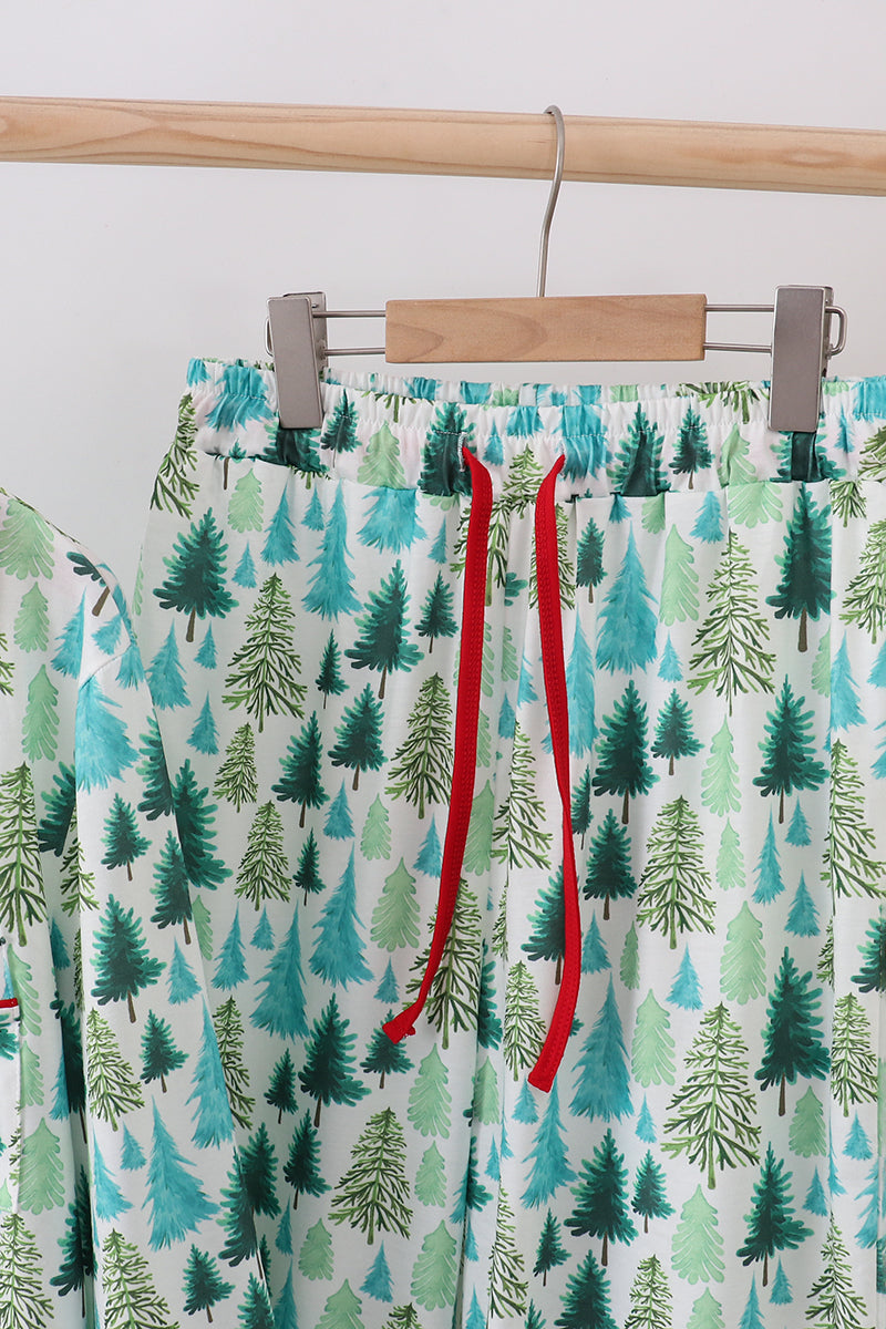 Pajama pants with forest pattern and red drawstrings on a hanger.