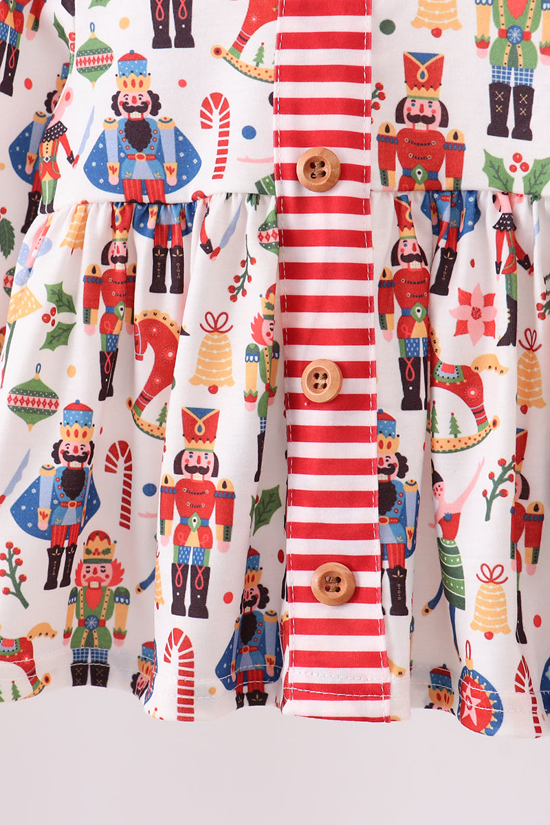 Fabric with Christmas-themed design featuring nutcrackers, candy canes, and buttons on a white background.