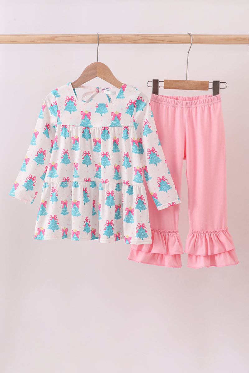 Children's outfit with a dress and pink pants hanging on a rack against a white background