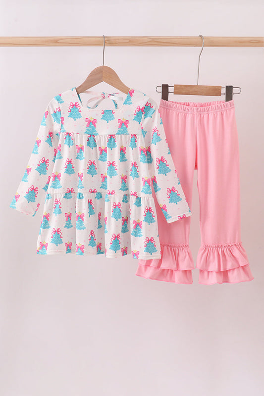 Children's outfit with a dress and pink pants hanging on a rack against a white background