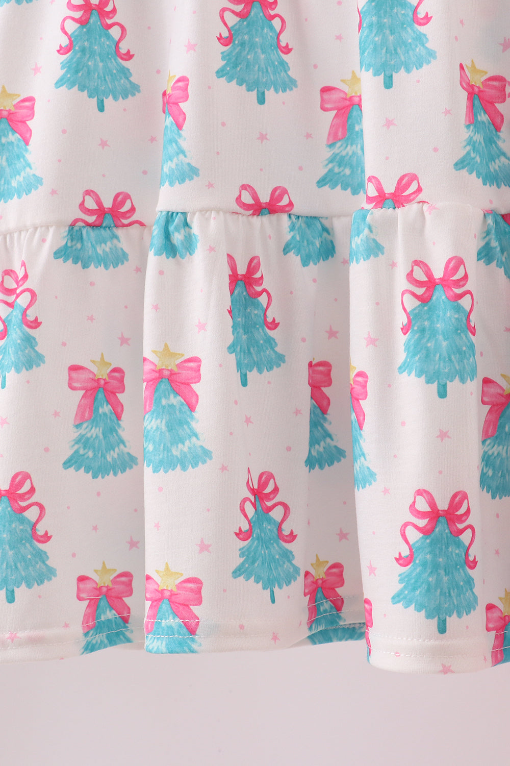 Pajama pants with blue Christmas tree and pink bow pattern on a white background