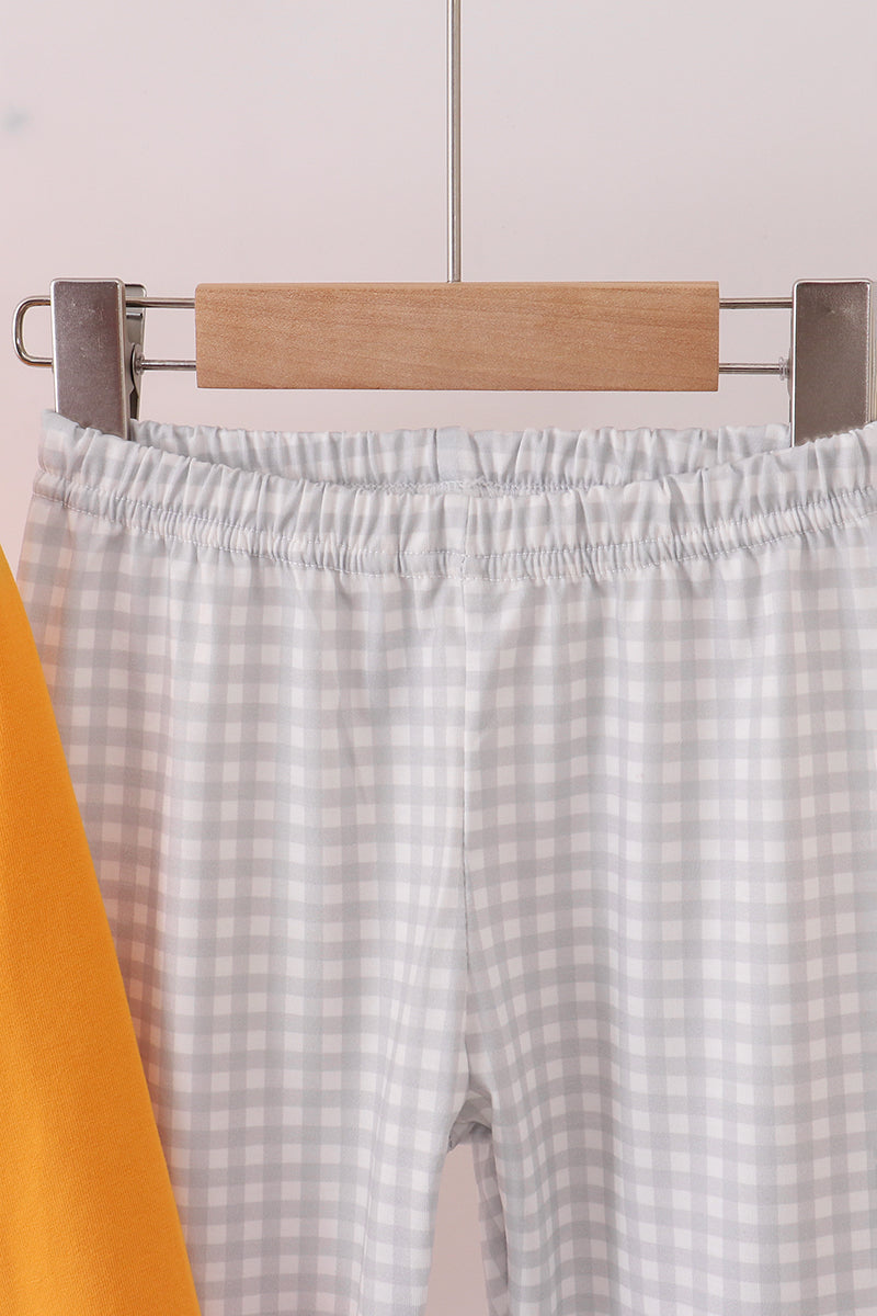 Checkered pants on a hanger against a light background
